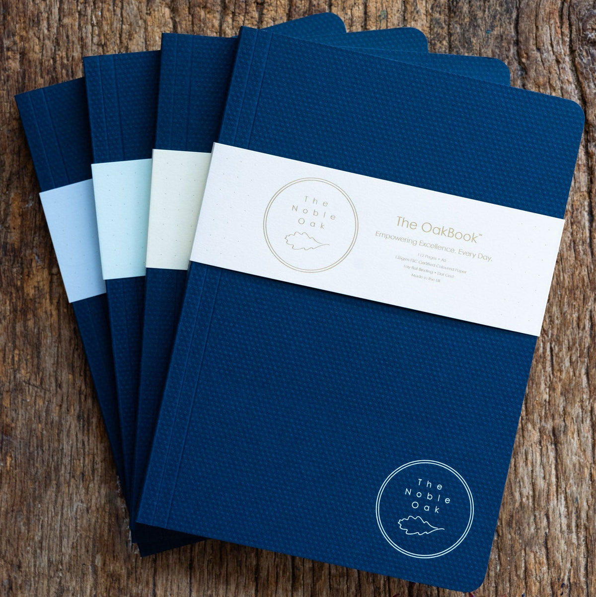 Set of blue notebooks with a brand label on a wooden surface