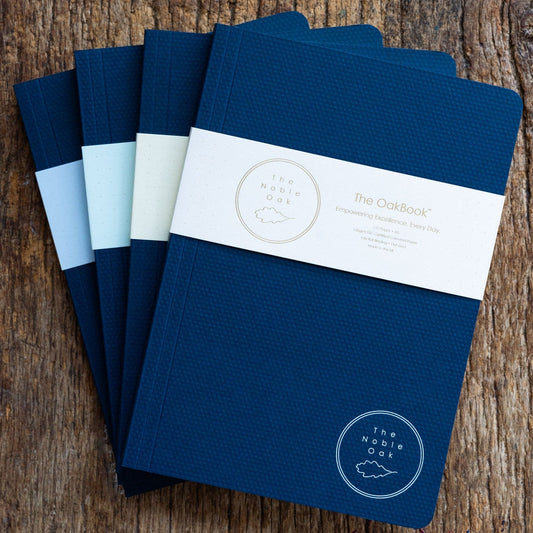 Set of blue notebooks with a brand label on a wooden surface